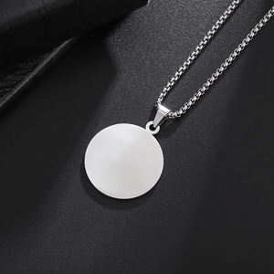 Macro detail of a minimalist silver stainless steel round pendant with a classic box chain