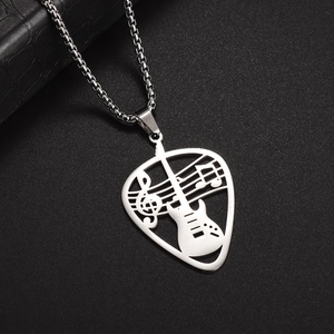 Macro shot of silver guitar pick necklace with hollowed-out musical note and treble clef details