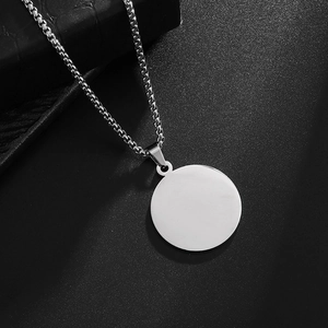 Detailed close-up of polished round stainless steel pendant with silver box chain link
