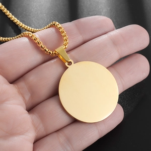 Detail of a minimalist gold round pendant necklace featuring a smooth polished finish