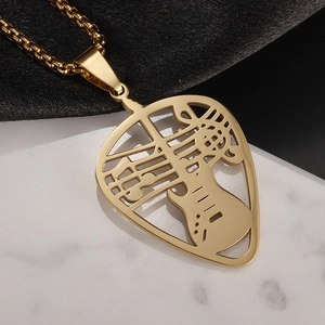 Detailed macro of golden heart-shaped guitar pick pendant with hollow music notes