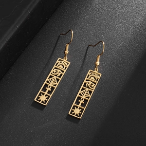 Macro shot of gold stainless steel Eye of Horus rectangular hollow drop earrings