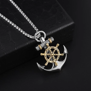 Detail of silver anchor pendant with golden helm on black crocodile texture