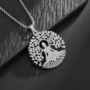 Macro detail of silver Tree of Life pendant with meditation silhouette on black background