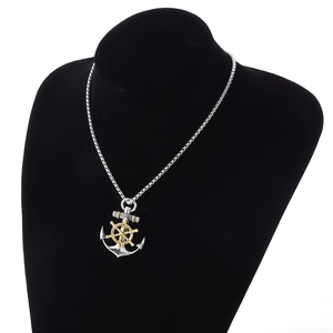 Retro nautical anchor and golden helm pendant necklace on a black jewelry display