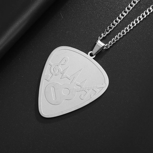 Detail view of silver stainless steel guitar pick necklace with engraved musical notes