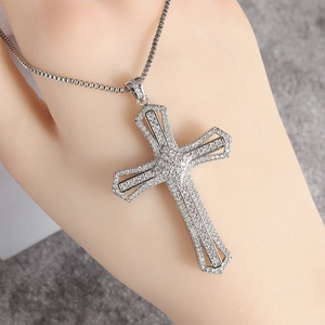 Macro shot of silver cross pendant with pavé cubic zirconia on a classic box chain