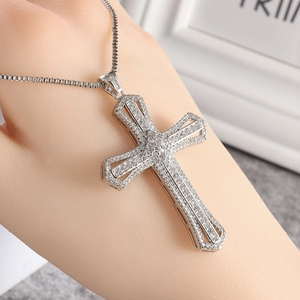 Macro shot of large silver-tone cross pendant with full white cubic zirconia inlay detail