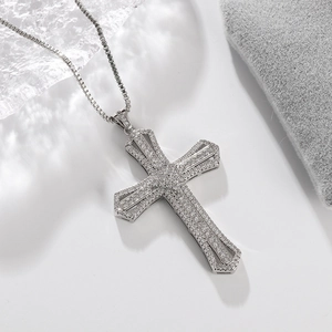 Detailed macro shot of silver cross pendant with shimmering white cubic zirconia and box chain