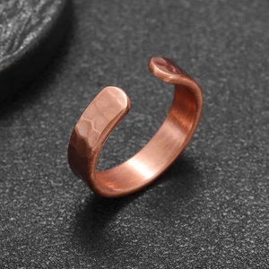Macro view showing the hammer-textured surface and brushed inner band of the copper ring