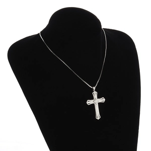 Detail view of silver alloy cross pendant with pavé cubic zirconia on a black velvet bust