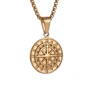 Detailed view of golden stainless steel compass pendant with N, E, S, W engravings