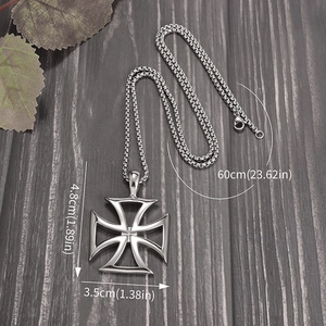 Detailed view of silver hollow iron cross pendant with size specs on wood background