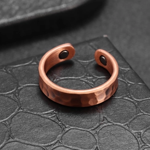 Detail showing the hammered texture and magnetic therapy stones on the copper open ring