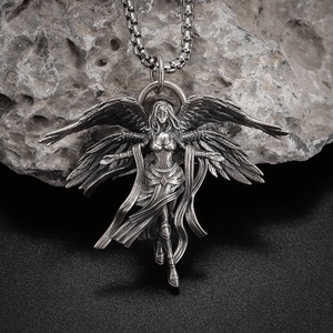 Macro view of vintage silver winged angel pendant on stone background with chain detail