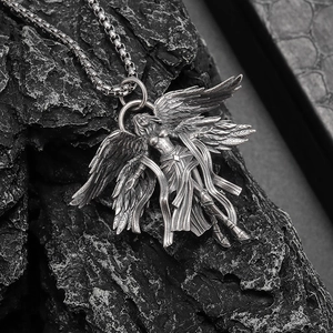 Detailed close-up of retro silver angel pendant with intricate wing texture on dark rock