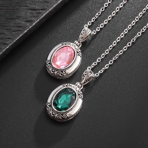Gros plan de pendentifs rétro ajourés avec zircons ovales roses et vert émeraude