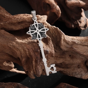 Vue macro d'un pendentif clé noeud de sorcière en acier inoxydable sur socle bois