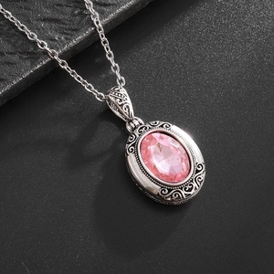 Détail macro du médaillon en argent vintage avec pierre précieuse rose ovale facettée