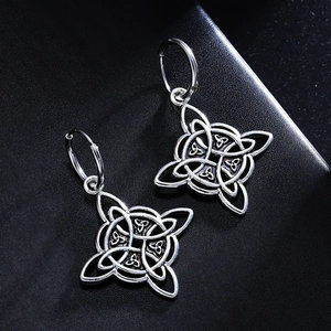 Nahaufnahme von silbernen Keltischen Knoten Ohrringen mit feiner Metalltextur auf Schwarz