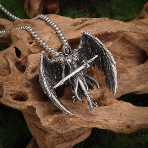 Detail of vintage silver Archangel Michael pendant with sword on a rustic wooden moss background
