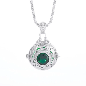Vintage hollow sphere locket necklace in silver with a large faceted green gemstone