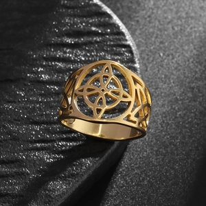 Macro shot of gold Celtic knot stainless steel ring on dark textured background