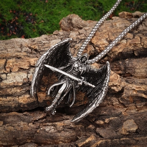 Close-up of vintage Archangel Michael necklace pendant on textured bark background