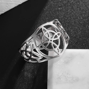 Close-up of wide hollow Celtic knot ring showing intricate silver metal geometry