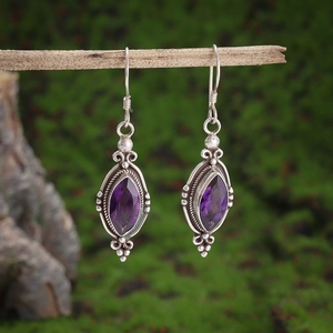 Vintage 925 silver earrings with marquise-cut amethysts on a natural wood branch