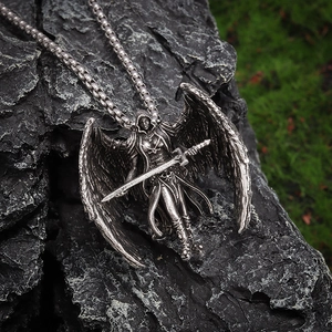 Close-up of Archangel Michael pendant with wings and sword on a black stone base