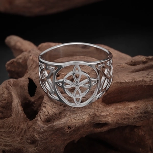 Detailed view of silver Celtic knot ring placed on rustic wood texture background