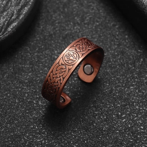Detail view of copper magnetic therapy ring with Celtic knot patterns and inner magnets