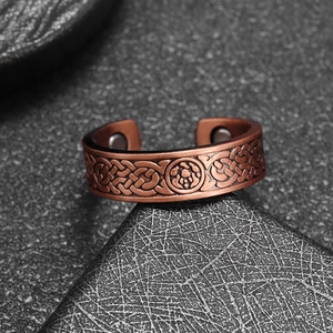 Detail of copper Celtic knot magnetic therapy ring showing engraved pattern and magnets