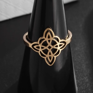 Gold stainless steel Celtic Witch Knot ring displayed on black professional ring stand