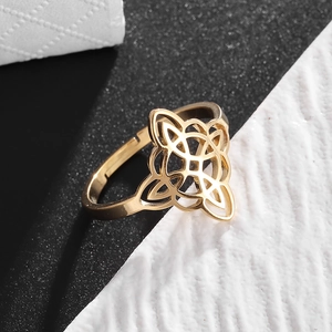 Detail of golden adjustable Celtic knot ring with intricate hollow geometric patterns
