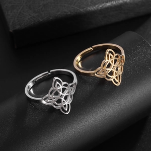 Close-up of gold and silver Celtic witch knot rings on a black display stand
