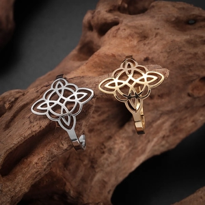 Macro detail of silver and gold Celtic witch knot open rings on rustic wood texture