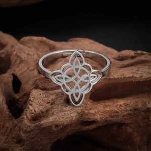 Detailed close-up of a silver Celtic witch knot ring on natural textured wood