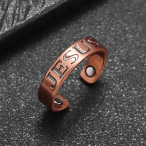 Macro detail of copper magnetic Jesus ring featuring embossed letters and therapy magnets