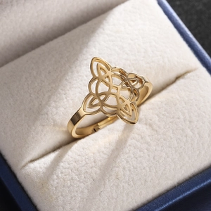 Macro shot of gold witch's knot ring showcased in a blue velvet gift box