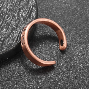 Macro detail of copper magnetic therapy ring with SUS engraving and black stone inlays