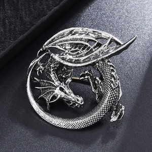 Close-up of vintage silver dragon brooch showing detailed scales and wings on leather
