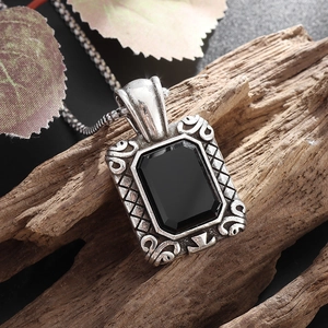Close-up of vintage square black gemstone pendant with ornate silver-tone metal frame