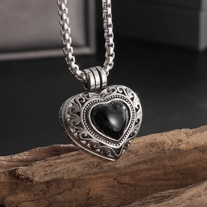 Vue macro détaillée du motif de vigne évidé sur le pendentif en forme de cœur du collier