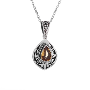 Vintage necklace with teardrop orange gemstone and silver swirl pattern pendant