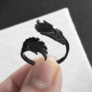Close-up of matte black wing-shaped adjustable ring with detailed feather textures