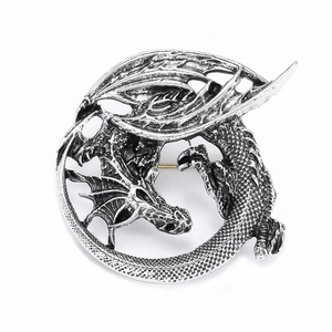 Vintage silver dragon brooch with detailed scales and wings on a clean white background