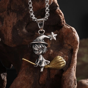 Macro shot of retro witch on broomstick pendant with golden accents and square chain