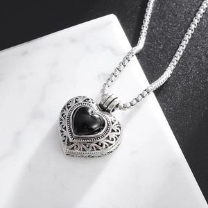 Détail macro du pendentif cœur vintage en argent avec pierre noire en forme de cœur